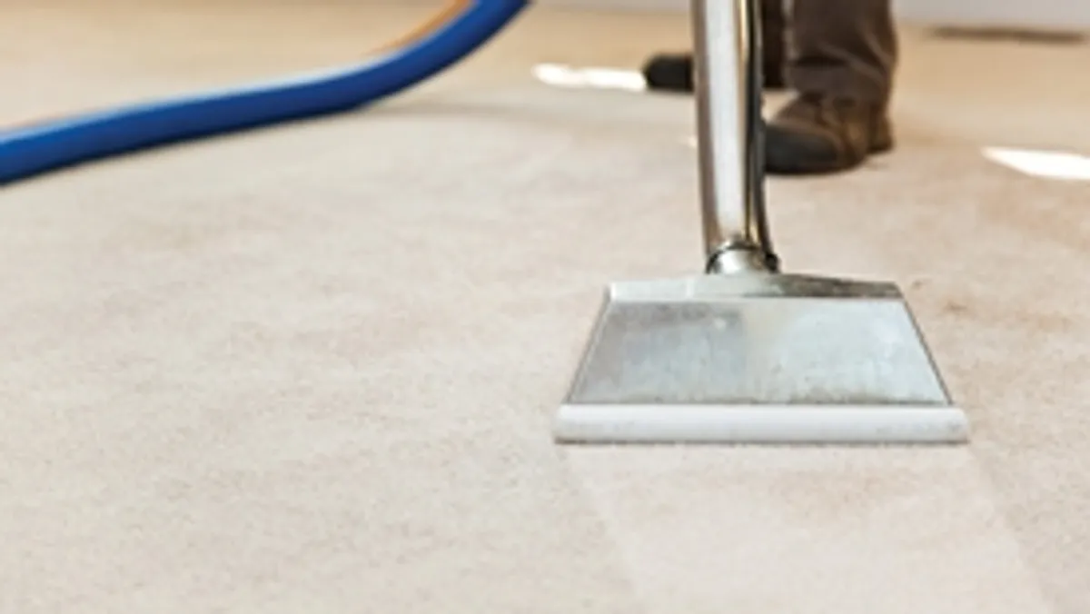 Carpet cleaning wand head gliding over a light carpet during hot-water extraction, Tulsa, OK.